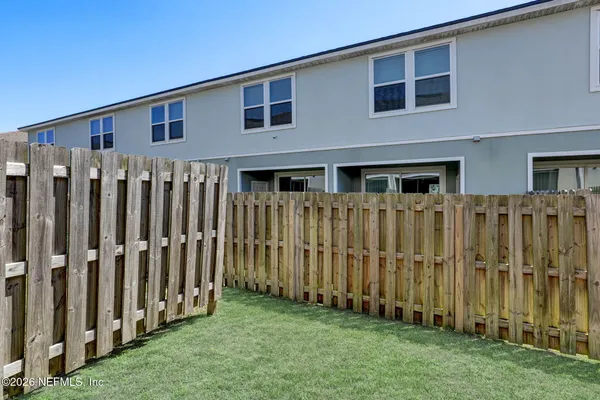a view of a house with wooden fence