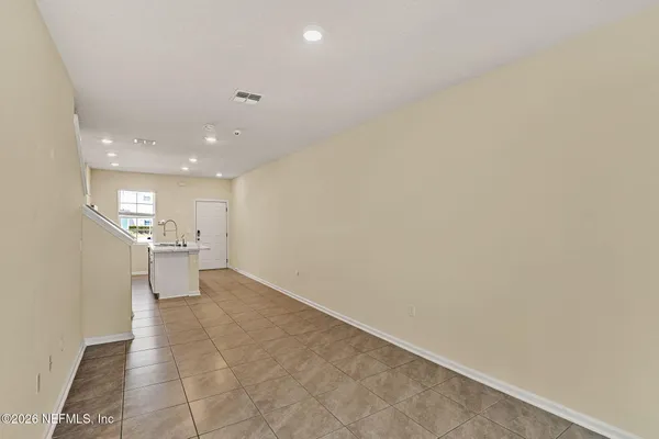 a view of a big room with wooden floor and a kitchen