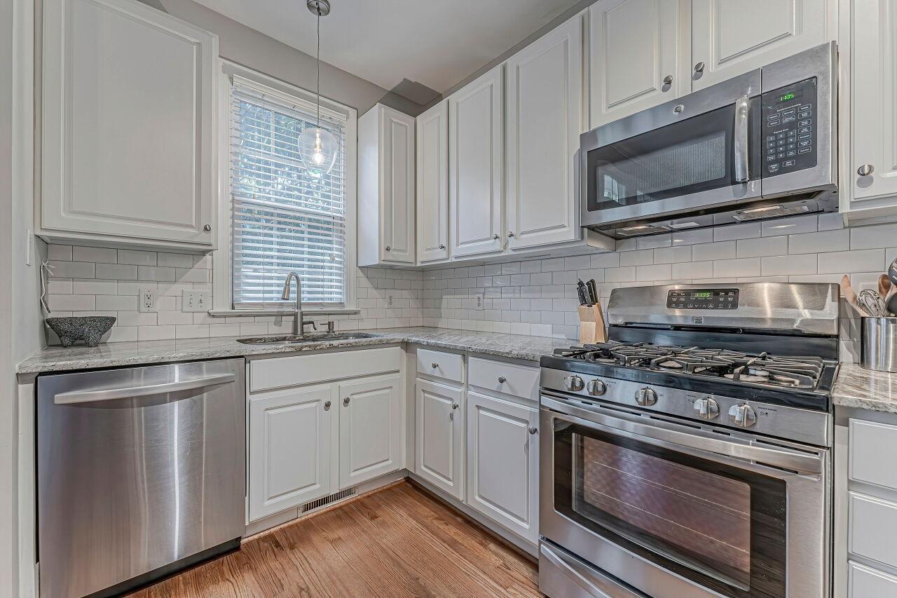 106 Hatfield Lane Raleigh, NC 27603 - Photo 11 of 29 a kitchen with stainless steel appliances granite countertop a stove microwave and sink