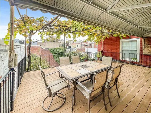 a view of a patio with a table chairs and wooden floor