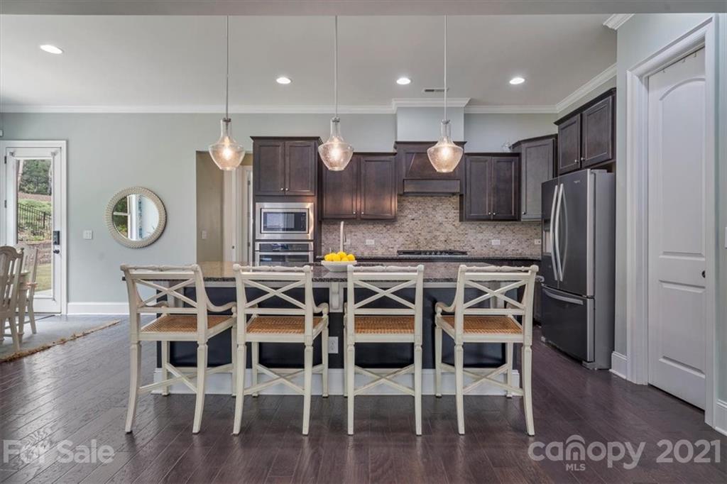 1526 Afton Way Fort Mill, SC 29708 - Photo 18 of 48 a kitchen with stainless steel appliances kitchen island granite countertop a wooden cabinets and chairs