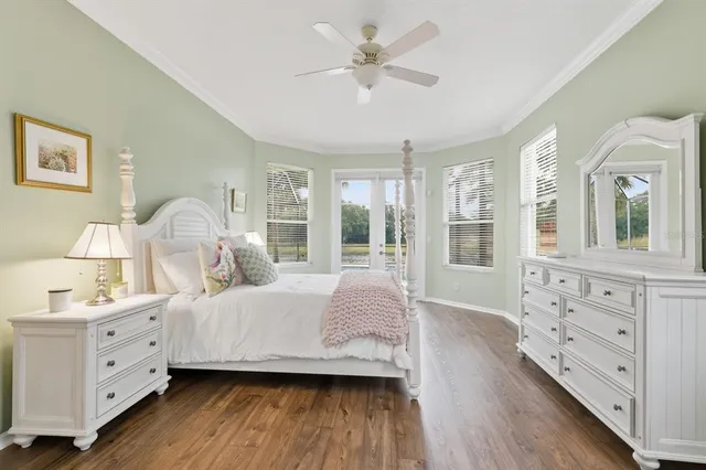 a bedroom with a large bed and wooden floor
