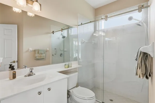 a bathroom with a sink toilet double vanity and shower