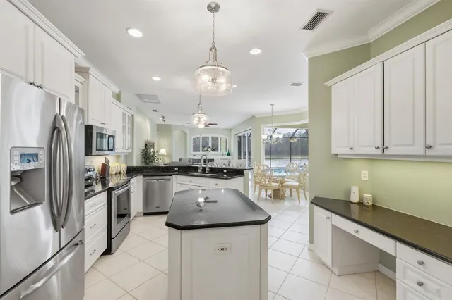 a kitchen with stainless steel appliances granite countertop a sink refrigerator and cabinets