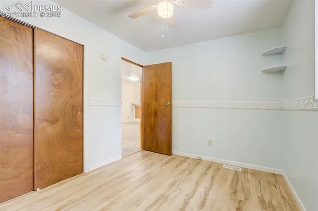 a view of a kitchen with refrigerator and wooden floor