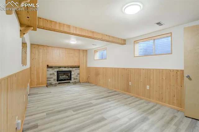 a view of empty room with wooden floor and fireplace