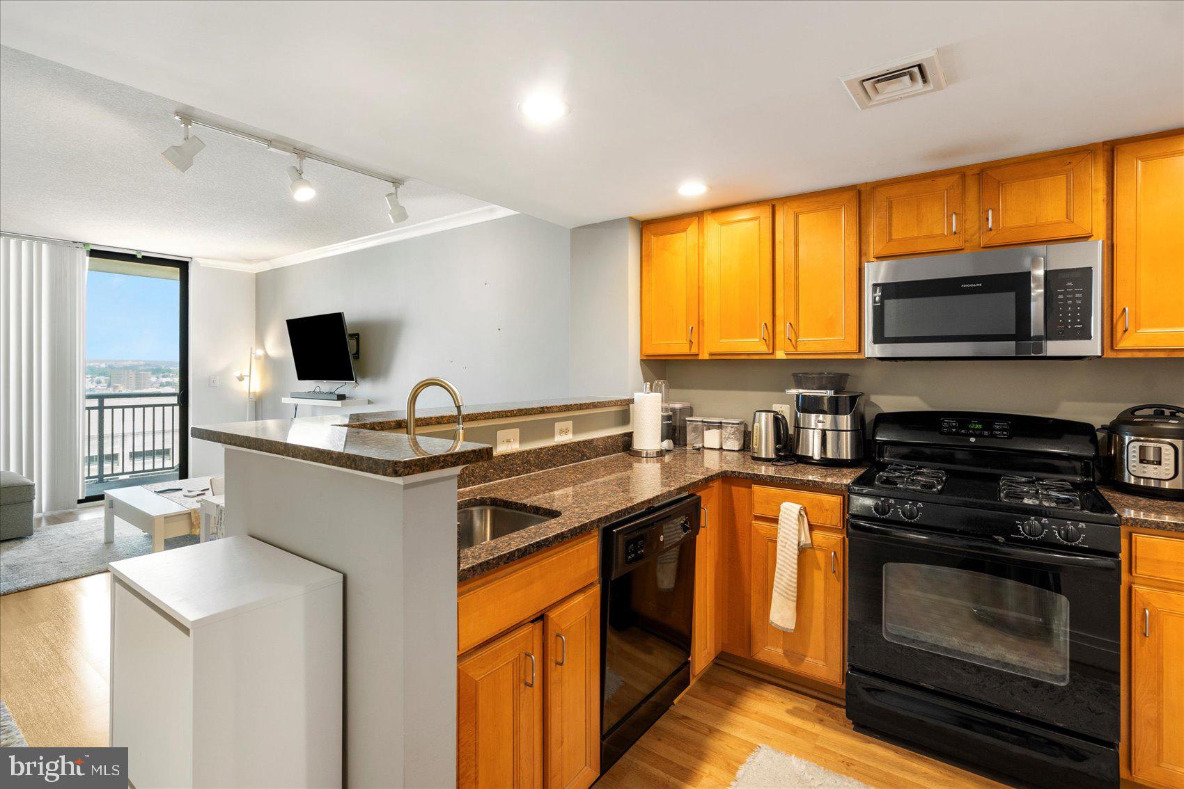 a kitchen with stainless steel appliances a stove sink microwave and refrigerator