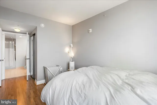 a spacious bedroom with a bed and wooden floor