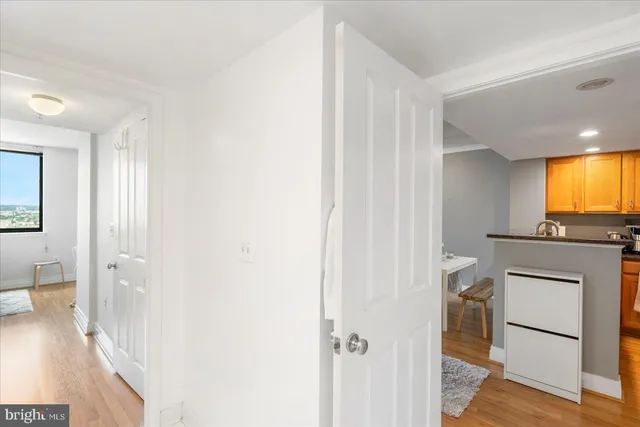 a view of a hallway with bathroom and wooden floor