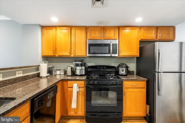 a kitchen with a sink a stove cabinets and a refrigerator