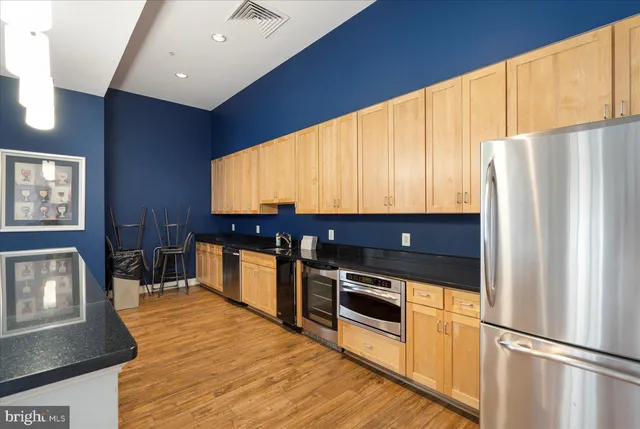 a kitchen with stainless steel appliances wooden cabinets and a stove top oven
