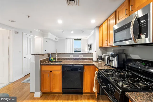 a kitchen with stainless steel appliances granite countertop a stove a sink and a microwave
