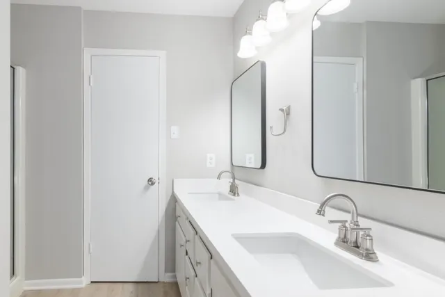 a bathroom with a double vanity sink and a mirror
