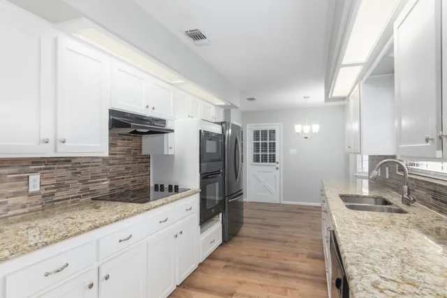 a kitchen with granite countertop a sink and stainless steel appliances