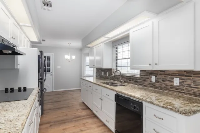 a kitchen with stainless steel appliances granite countertop a sink stove and cabinets