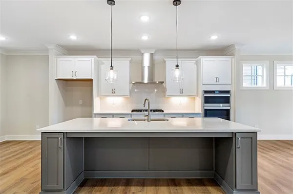 a kitchen with kitchen island a counter space a sink appliances and cabinets