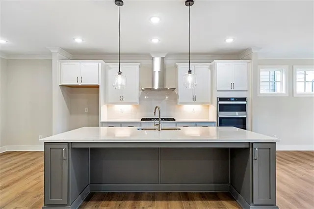 a kitchen with kitchen island a counter space a sink appliances and cabinets