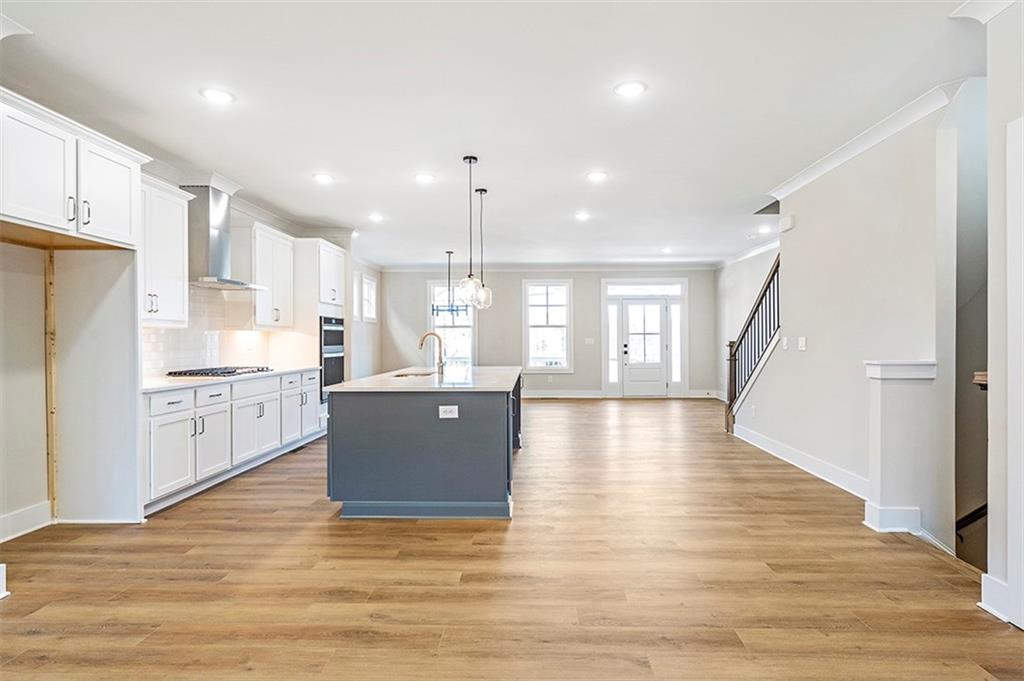 152 Palm Street Holly Springs, GA 30115 - Photo 17 of 33 a kitchen with stainless steel appliances granite countertop a refrigerator a sink dishwasher a stove and white countertops with wooden floor