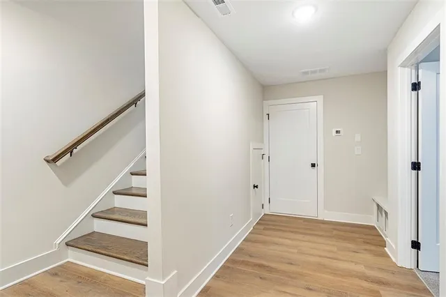 a view of a hallway with wooden floor and entryway