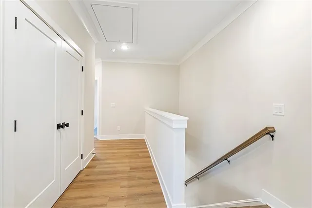 a view of a hallway with wooden floor and staircase
