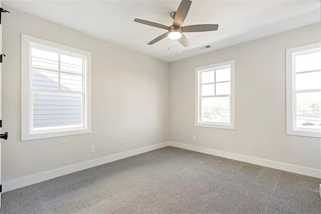 an empty room with a window and a fan