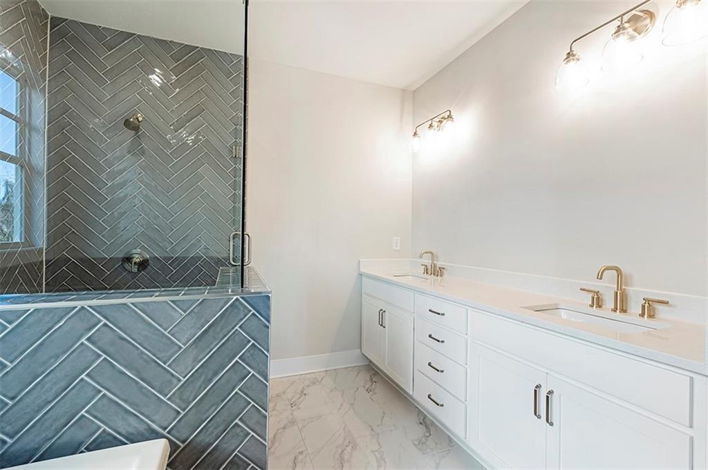 152 Palm Street Holly Springs, GA 30115 - Photo 32 of 33 a bathroom with a double vanity sink a mirror and a shower