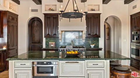 a kitchen with stainless steel appliances granite countertop a stove and cabinets