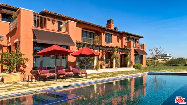 a view of a building with a swimming pool and sitting area