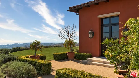 a view of a house with a yard and potted plants