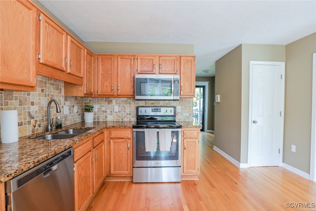 11400 Bailey Mountain Trail Midlothian, VA 23112 - Photo 23 of 41 a kitchen with granite countertop a stove a sink and a refrigerator