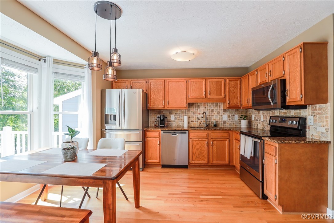 11400 Bailey Mountain Trail Midlothian, VA 23112 - Photo 27 of 41 a kitchen with stainless steel appliances kitchen island granite countertop a refrigerator a stove top oven a sink dishwasher a dining table and chairs with wooden floor