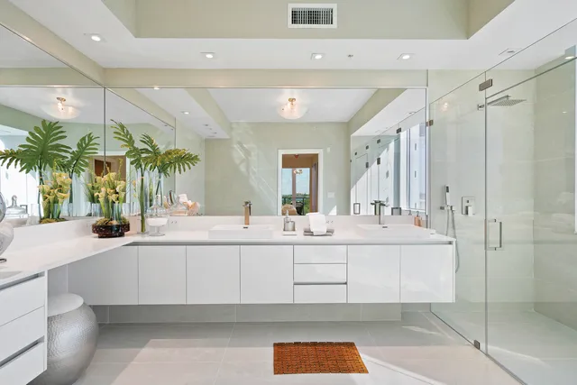 a large white bathroom with a tub a mirror and shower