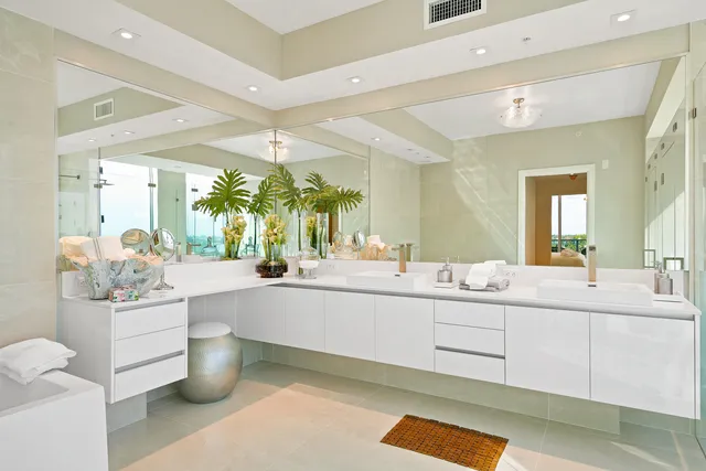 a large white bathroom with a double vanity sink a mirror and a bathtub