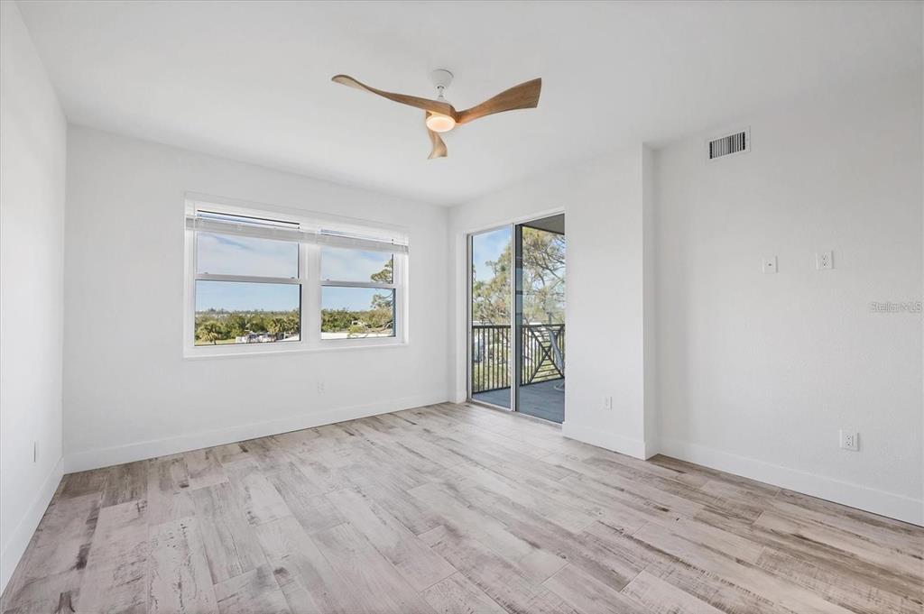 9203 Griggs Road, Unit 204 Englewood, FL 34224 - Photo 13 of 32 a view of an empty room with a window and wooden floor
