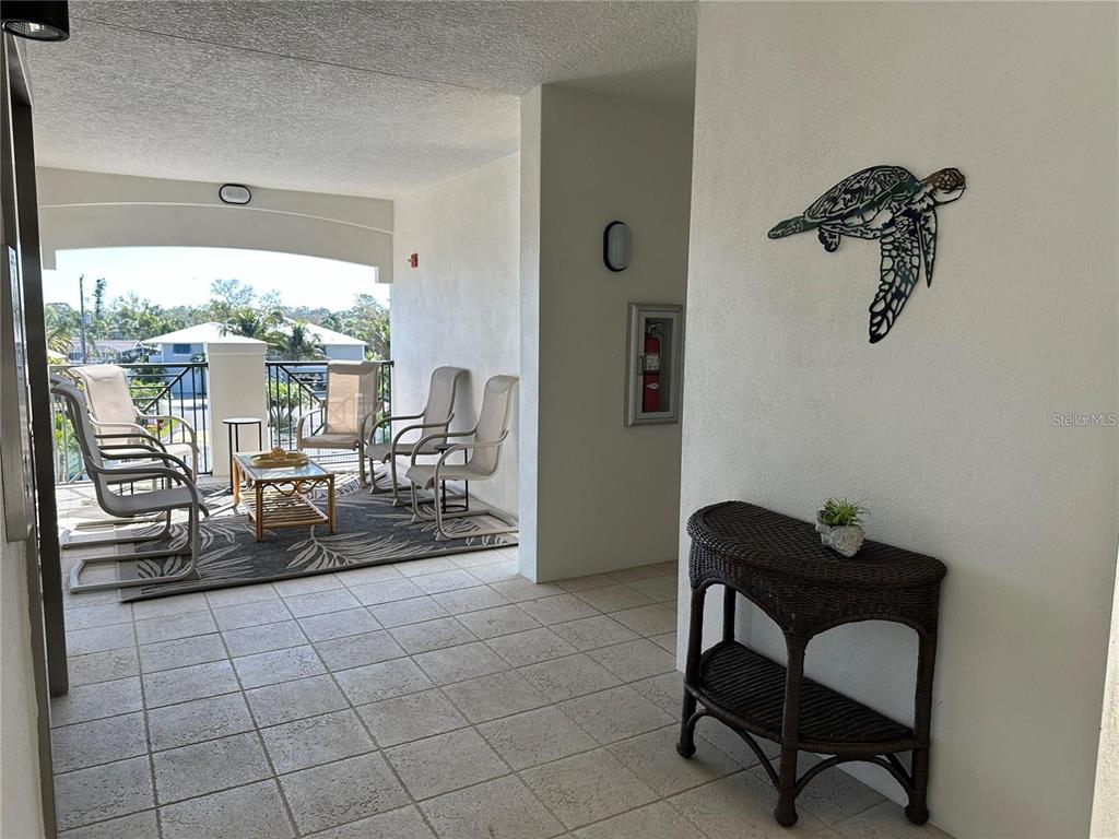 9203 Griggs Road, Unit 204 Englewood, FL 34224 - Photo 23 of 32 a living room with couches and a potted plant next to a window