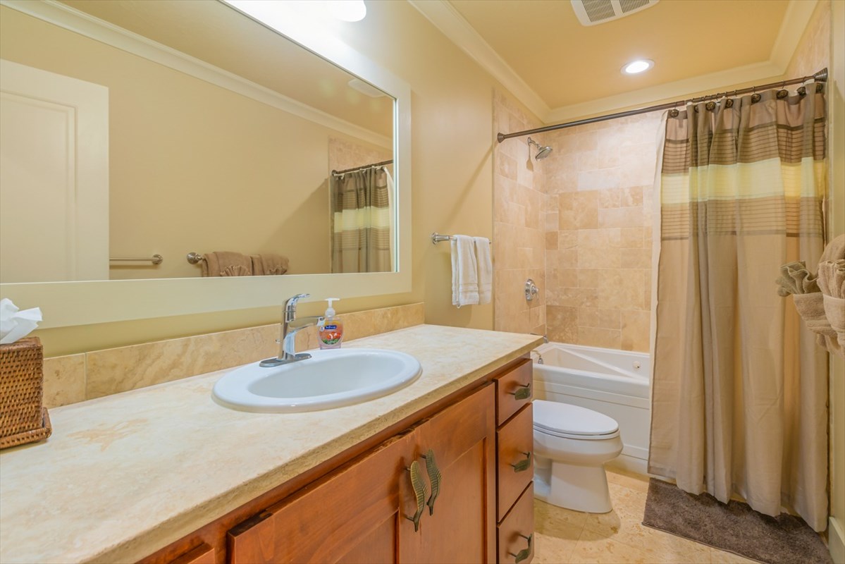 2387 Ho'ohu Road, Unit 221 Koloa, HI 96756 - Photo 19 of 25 a bathroom with a sink a toilet a mirror and shower