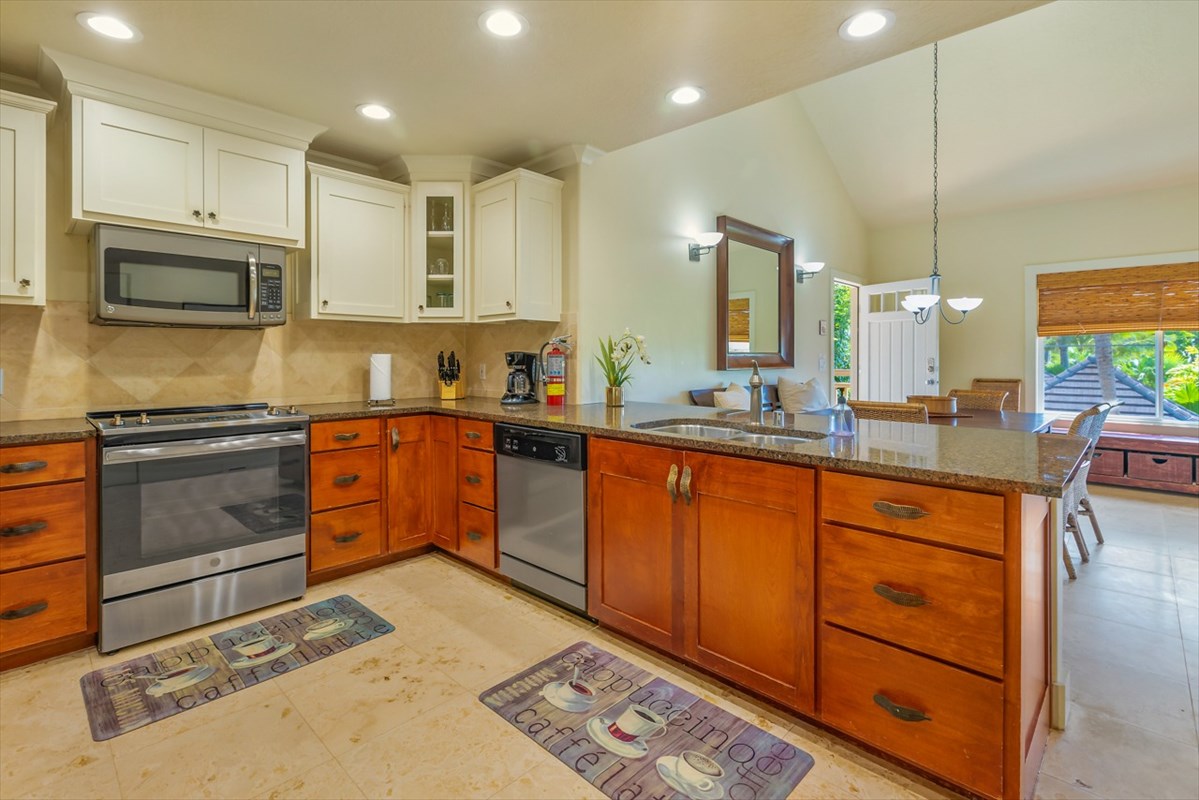 2387 Ho'ohu Road, Unit 221 Koloa, HI 96756 - Photo 3 of 25 a kitchen with stainless steel appliances kitchen island granite countertop a stove a sink and a microwave