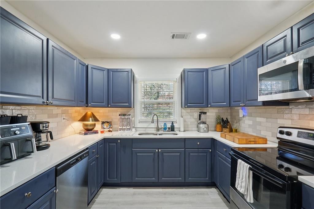 1145 Fayetteville Road Southeast Atlanta, GA 30316 - Photo 12 of 24 a kitchen with a sink a stove and cabinets