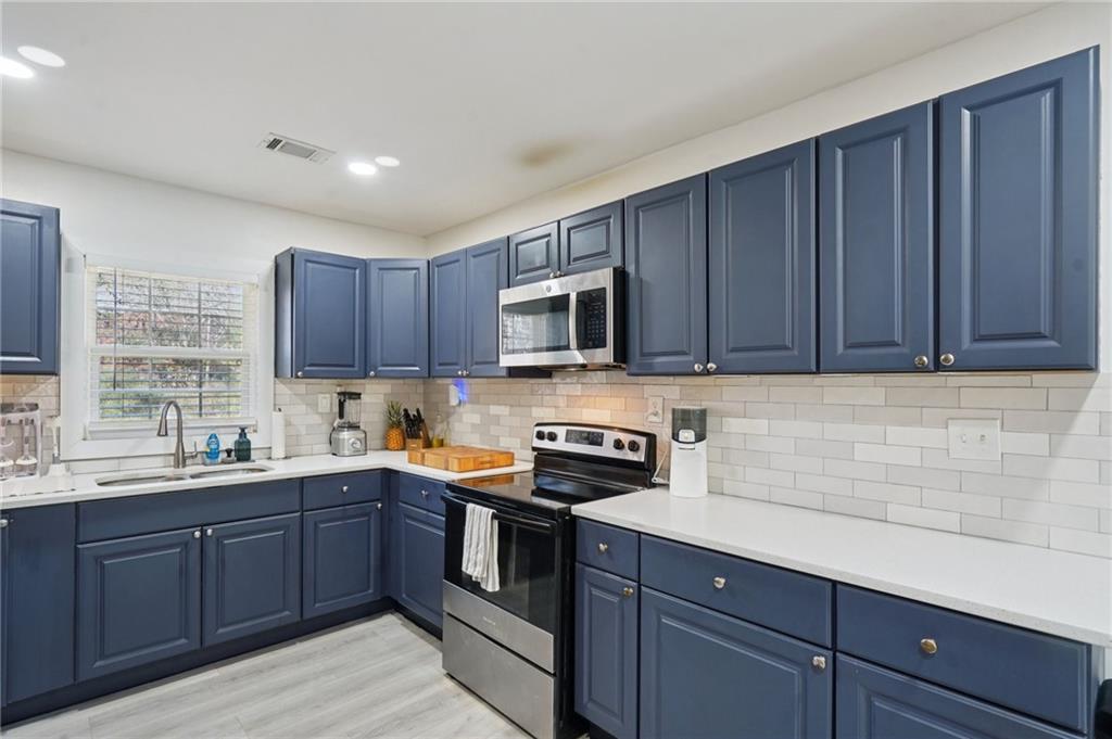 1145 Fayetteville Road Southeast Atlanta, GA 30316 - Photo 13 of 24 a kitchen with sink a microwave and cabinets
