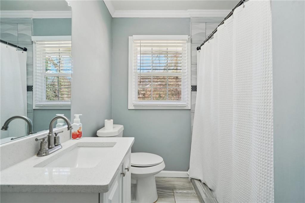 1145 Fayetteville Road Southeast Atlanta, GA 30316 - Photo 22 of 24 a bathroom with a sink a toilet and a window