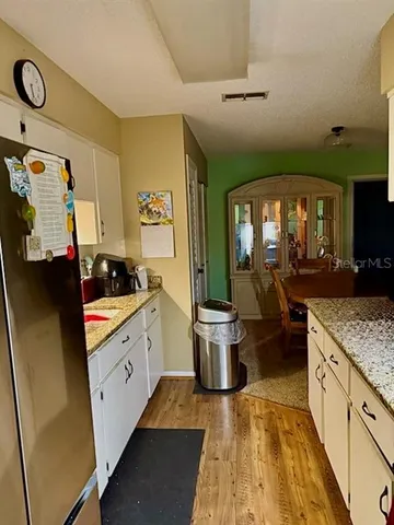 a kitchen with stainless steel appliances granite countertop a sink and a refrigerator