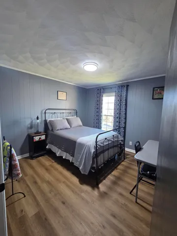 a bedroom with a bed a chair and a potted plant