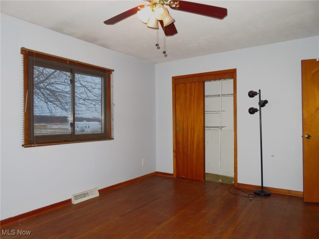 12214 Thompson Road Vermilion, OH 44089 - Photo 14 of 29 The Primary Bedroom has a double door closet, hardwood flooring & a ceiling fan/light