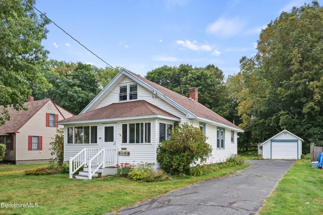 a front view of a house with a garden and yard