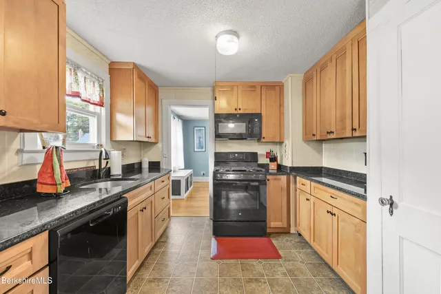 a kitchen with stainless steel appliances granite countertop a stove sink microwave and cabinets