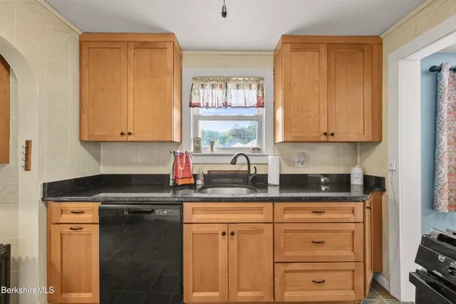 a kitchen with granite countertop a sink cabinets and window