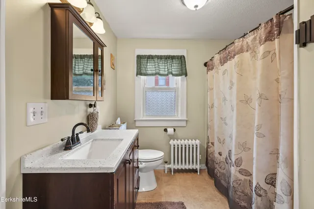 a bathroom with a sink a toilet and a window