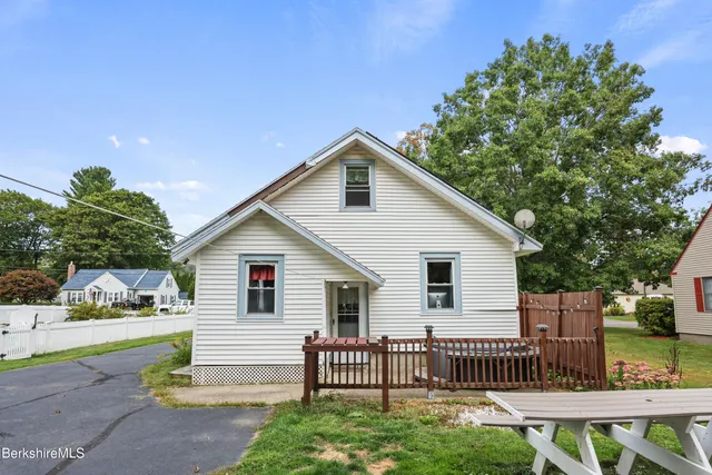 a view of a house with a yard and sitting area