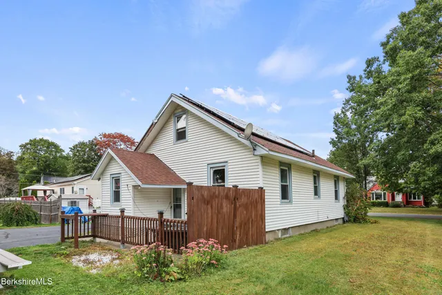 a backyard of a house with table and chairs