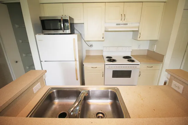 a kitchen with a sink a stove and microwave